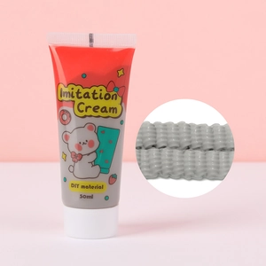 Detalle de pegamento crema gris de 50ml con textura 3D para manualidades y fundas de móvil