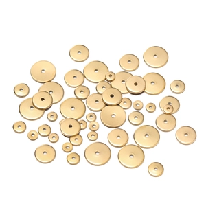 Makro-Detail goldener flacher Abstandsperlen aus Edelstahl in verschiedenen Größen für Schmuck