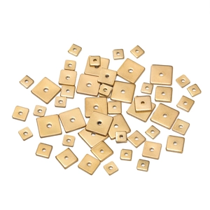 Detailed macro view of gold square stainless steel spacer beads with center holes for DIY