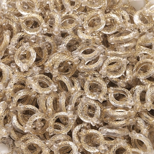 Makroaufnahme ovaler Acrylperlen mit goldenem geometrischem Muster für DIY-Schmuck