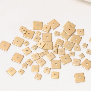 Macro shot of assorted golden square stainless steel beads with center holes for DIY jewelry