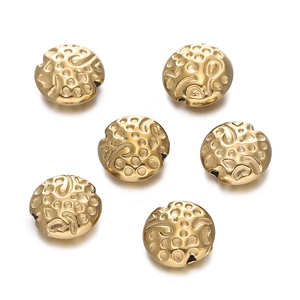 Macro detail of six golden stainless steel flower spacer beads with embossed floral patterns