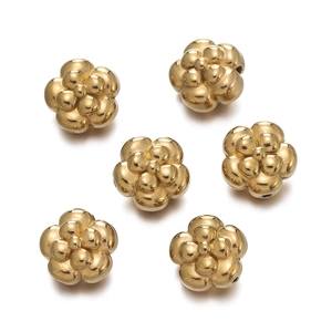 Detailed macro view of six gold floral stainless steel spacers for DIY jewelry making