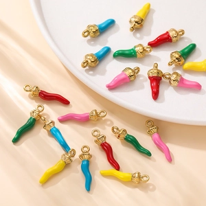 Primer plano de dijes de chile de esmalte de colores con anillos dorados para joyería DIY