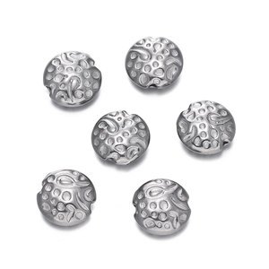 Detailed macro view of six silver stainless steel floral beads with textured finish