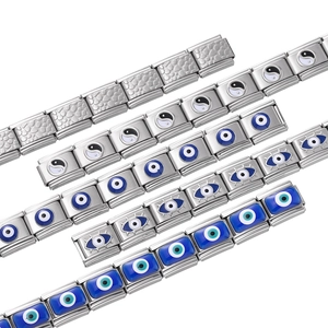 Gros plan de maillons de bracelet italien en acier avec motifs œil protecteur et yin yang