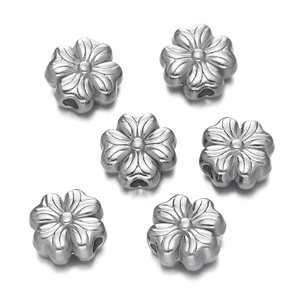 Detailed macro view of six silver stainless steel flower beads with central threading holes