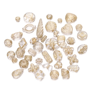 Detailansicht von DIY-Acrylperlen mit Goldfolienmustern in Herz- und Blumenformen für Schmuck