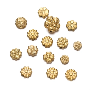 Macro shot of gold stainless steel flower beads and clover spacers for DIY jewelry making