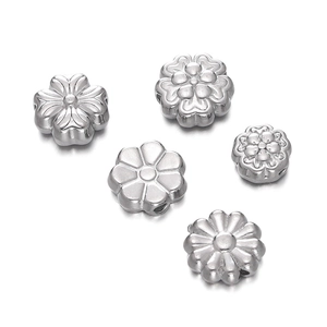 Macro detail of various silver stainless steel flower spacer beads for DIY jewelry making
