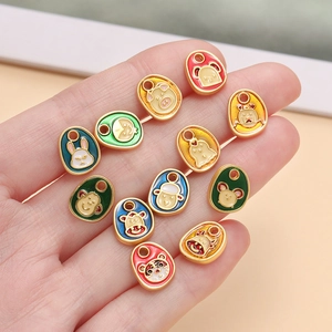 Cartoon Chinese zodiac pendants in colorful enamel gold finish held in palm