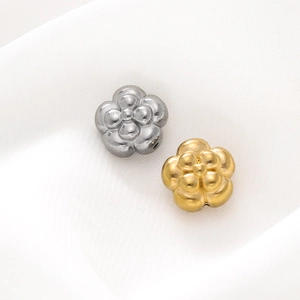 Detailed macro view of 3D gold and silver flower beads on soft silk for DIY jewelry making