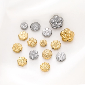 Detailed macro view of gold and silver flower spacer beads for DIY jewelry making