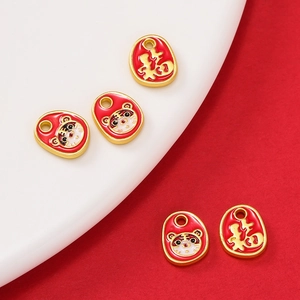 Detail of red enamel tiger and Fu character pendants for DIY jewelry crafting
