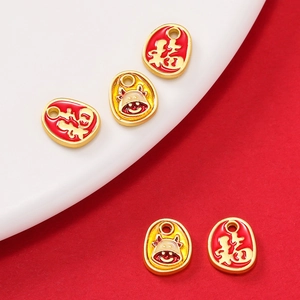 Close-up of alloy enamel Fu character and cartoon zodiac ox charms for jewelry DIY