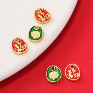 Macro shot of red and green enamel Fu character pendants with traditional gold plating