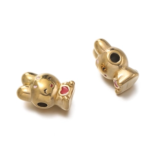 Dettaglio di perline a forma di coniglio dorato con smalto rosa e cuori rossi per fai da te