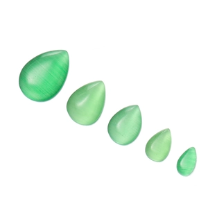 Detail view of five light green teardrop cat eye glass cabochons in varying sizes