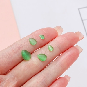 Macro detail of green teardrop cat-eye glass stones for DIY jewelry making