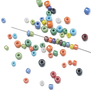 Colorful seed beads set with stainless steel beading needle on a white background