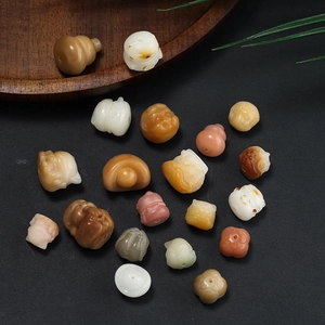 Detailed view of hand-carved Bodhi seed charms with traditional patterns on black background