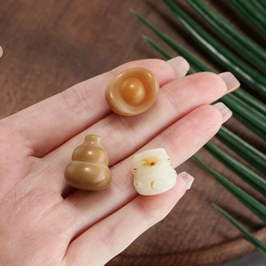 Detailed macro view of carved Bodhi root beads in sycee, gourd, and lucky cat shapes