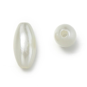 Macro shot of oval and round ivory ABS faux pearl beads with pre-drilled holes for jewelry DIY