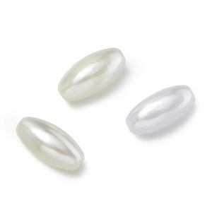 Macro detail of oval imitation pearl beads with smooth luster and pre-drilled holes