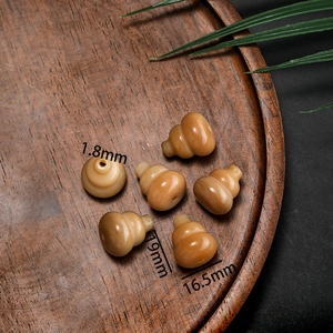 Detailed macro of five gourd-shaped warm yellow bodhi root beads on wooden tray