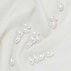 Macro shot of high-gloss white oval faux pearls for DIY jewelry making and hair accessories