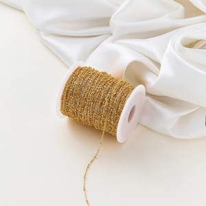 Detail of 1.8mm gold-plated beaded O-chain on spool for DIY jewelry making supplies