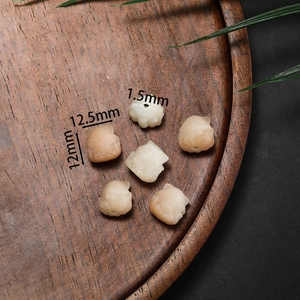 Detailed view of hand-carved Bodhi root beads in warm lotus and hand shapes for DIY jewelry