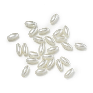 Macro shot of oval cream white ABS imitation pearls with smooth pearlescent coating for DIY