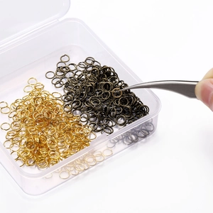 Λεπτομέρεια από κρίκους DIY σε χρυσό και μπρονζέ χρώμα με λαβίδα σε κουτί