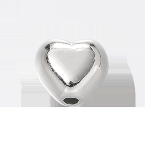 Dettaglio macro di una perla CCB a forma di cuore argento con finitura metallica e foro