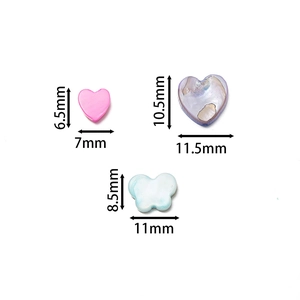 Close-up of pink heart and iridescent shell-style beads for DIY jewelry making
