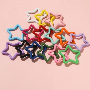 Close-up of colorful star-shaped metal keychains in various lacquer finishes for DIY crafts
