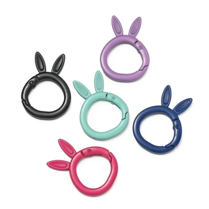 Close-up of five colorful rabbit-eared alloy spring rings for DIY keychains and bag charms