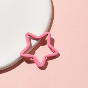 Detailed view of a pink painted metal star keychain accessory on a white display stand