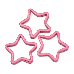 Macro detail of three pink star-shaped metal split key rings for DIY crafts and keychains