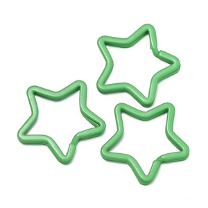 Close-up of three grass green star-shaped metal key rings for DIY accessories