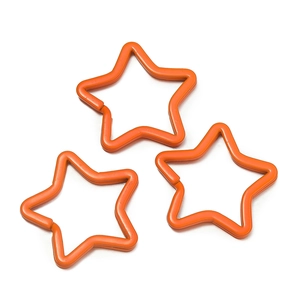Close-up of three orange star-shaped painted metal keyrings for DIY accessories