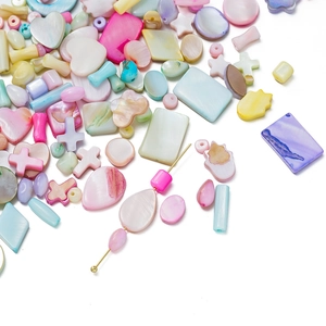 Detailed view of colorful shell beads in heart and cross shapes for DIY jewelry making