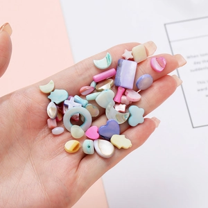 Colorful mixed heart and star shell beads for DIY jewelry making held in hand