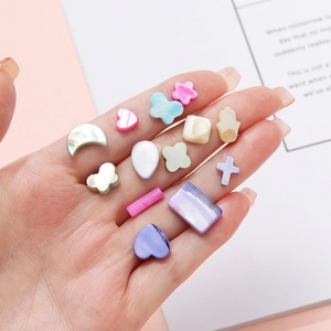 Close-up of colorful heart and star shell beads for DIY jewelry making in various shapes