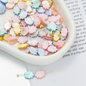 Macro shot of colorful shell beads in Hamsa Hand shape for DIY jewelry making and crafts
