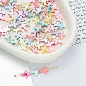 Macro shot of colorful cross-shaped faux pearl beads for DIY jewelry making and crafts