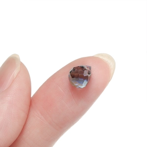Detail of multi-faceted pear-shaped glass crystal bead in iridescent purple and blue