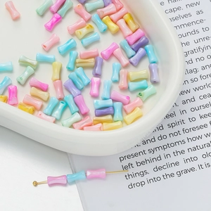 Macro shot of colorful pearlescent resin beads in bone shape for DIY jewelry making
