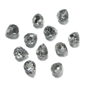 Macro view of dark grey faceted glass teardrop beads with polished geometric surfaces